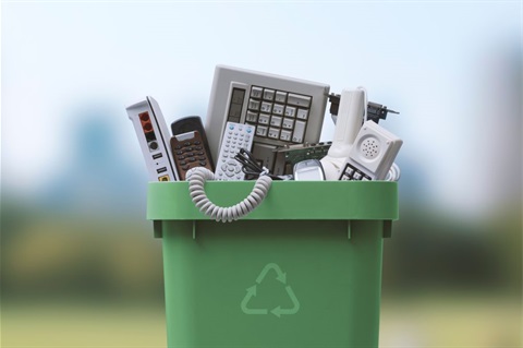 Plastic green bin with a recycle icon containing electronics